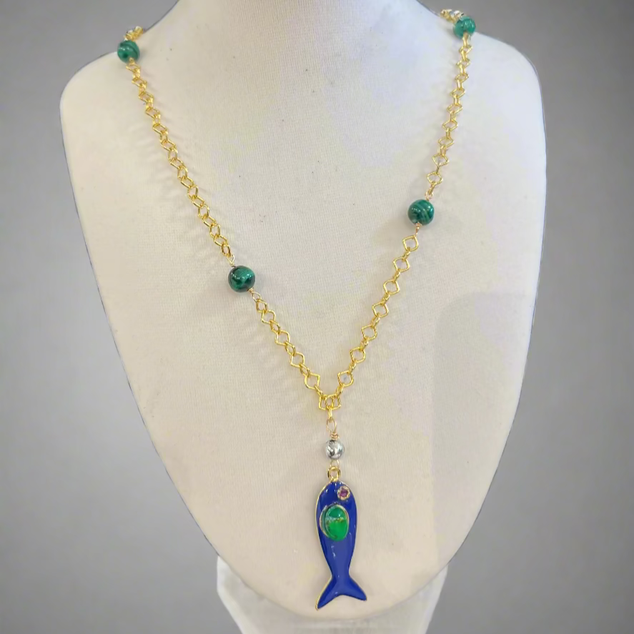 Necklace with a fish pendant on a mannequin bust against a gray background