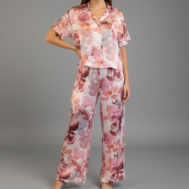 A mannequin displaying a pink and purple floral print pajama set with long sleeves and a round neckline.