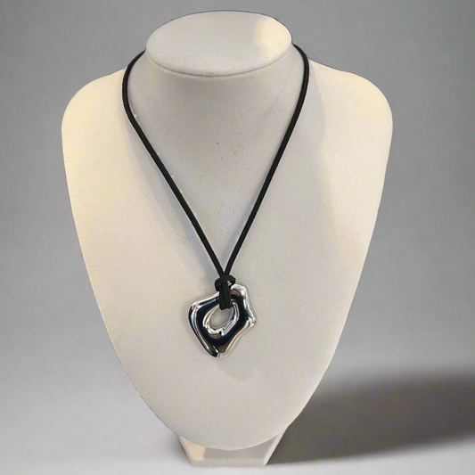 Necklace with a heart-shaped pendant on a mannequin bust against a black background