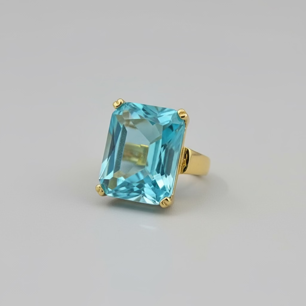 Small blue gemstone on a white stand on a desk with a laptop in the background