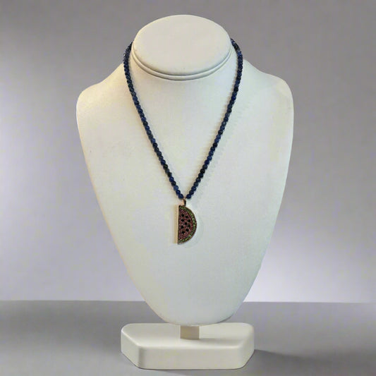 A blue moonstone necklace with a pendant shape on a white mannequin bust on a white background