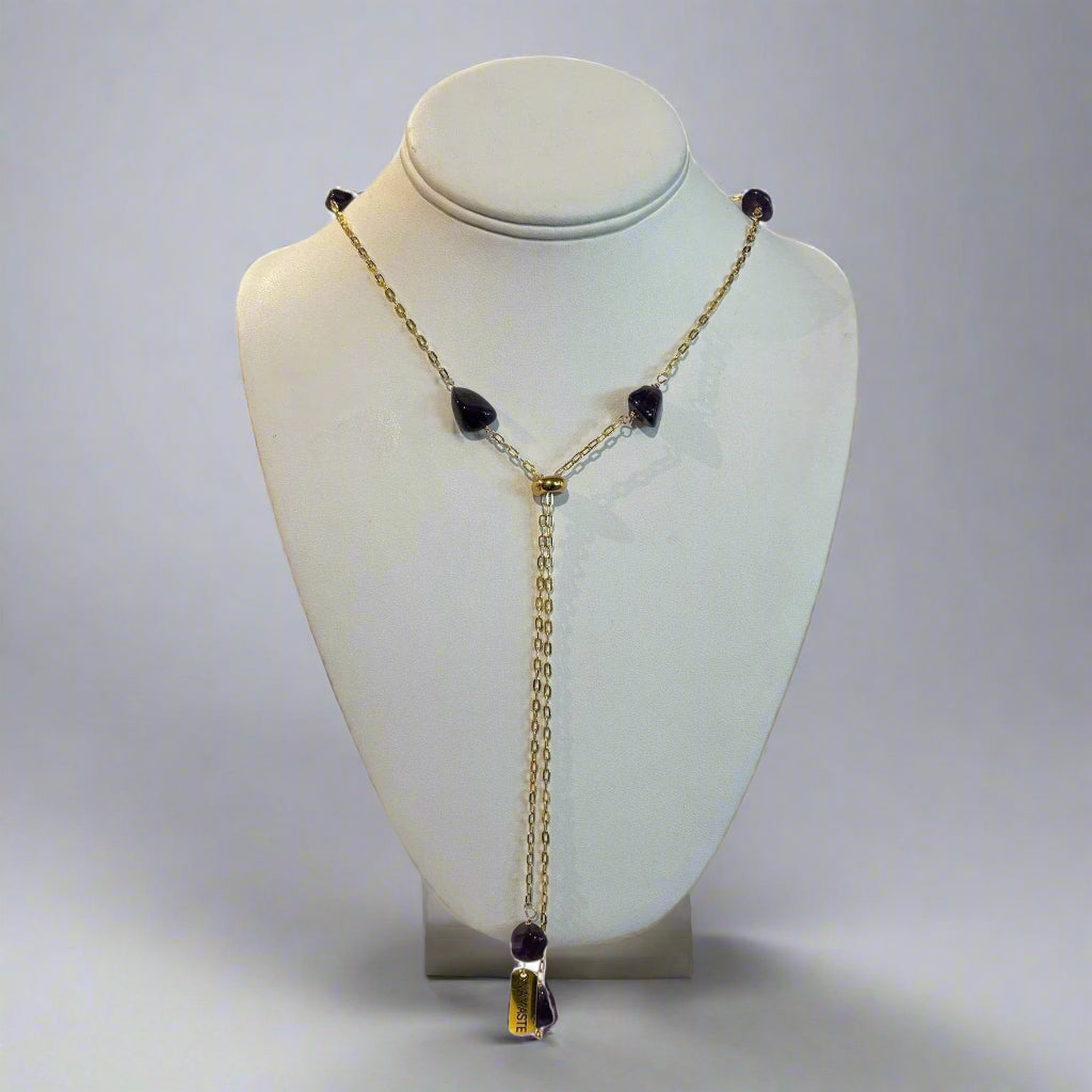 Necklace with black beads and gold chain on a white mannequin bust
