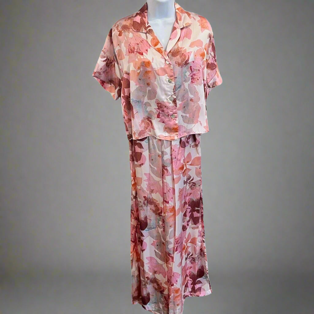 A mannequin displaying a pink and purple floral print pajama set with long sleeves and a round neckline.
