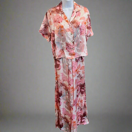 A mannequin displaying a pink and purple floral print pajama set with long sleeves and a round neckline.