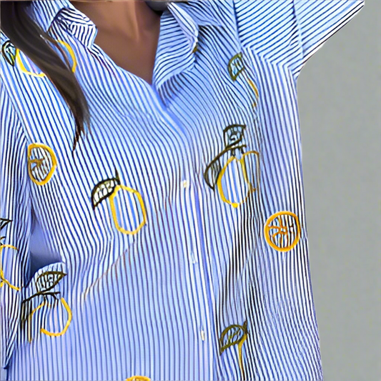 Blue striped shirt with embroidered lemon designs on a white background