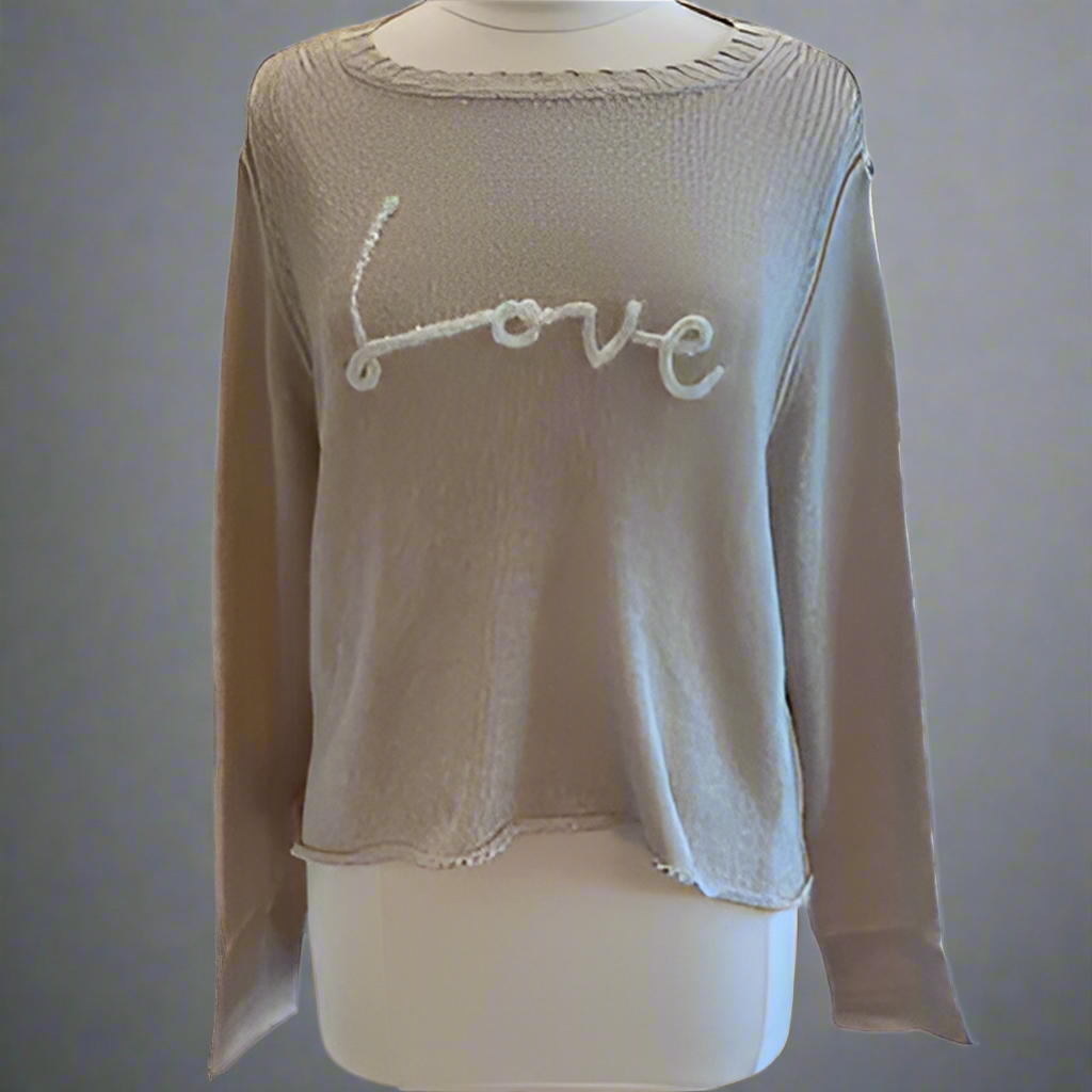 A beige crew sweater with the word 'love' knitted in cursive on the front.