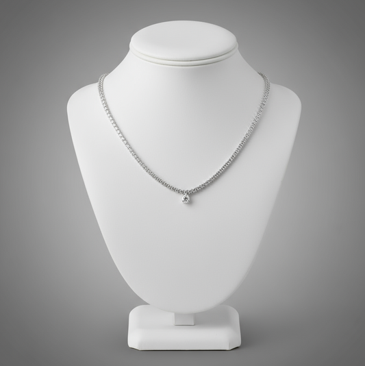 Silver necklace on a white mannequin bust against a gray background
