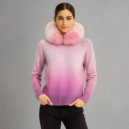 Person wearing a pink gradient sweater with a fur collar against a plain background