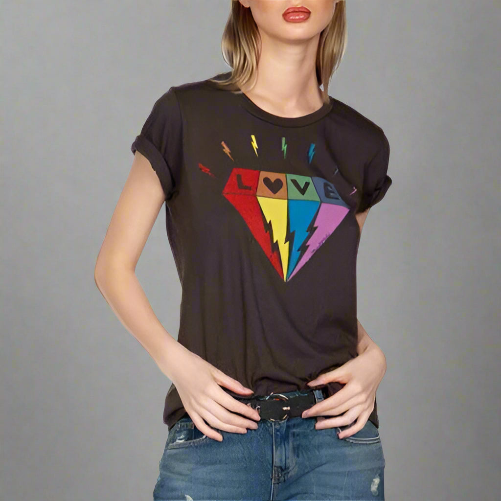 Woman wearing a black t-shirt with colorful graphic design and blue jeans on a white background